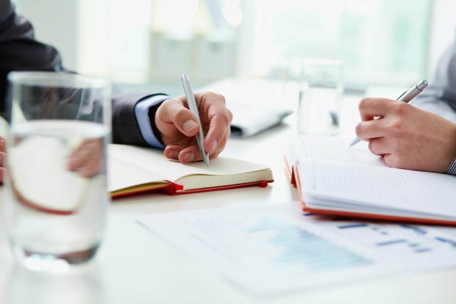 Teilnehmer bei der praktischen Budgetplanung mit Taschenrechner und Unterlagen